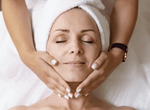 Smiling woman with curly hair and glowing skin.