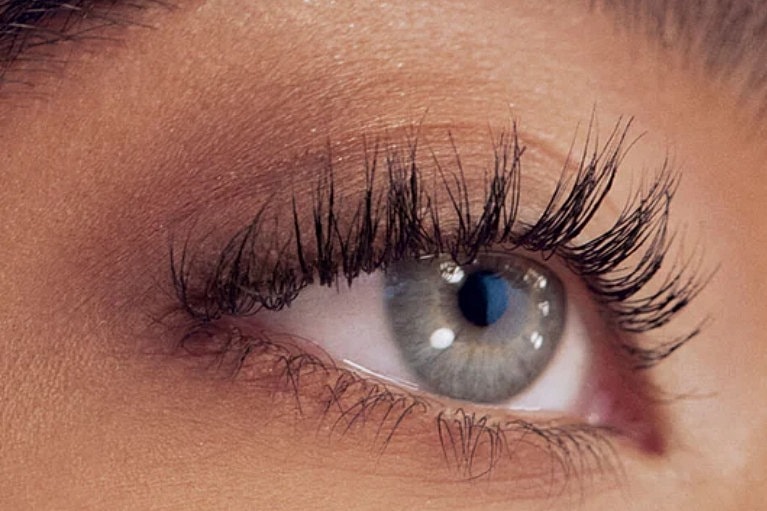 Close-up of a blue eye with long eyelashes.