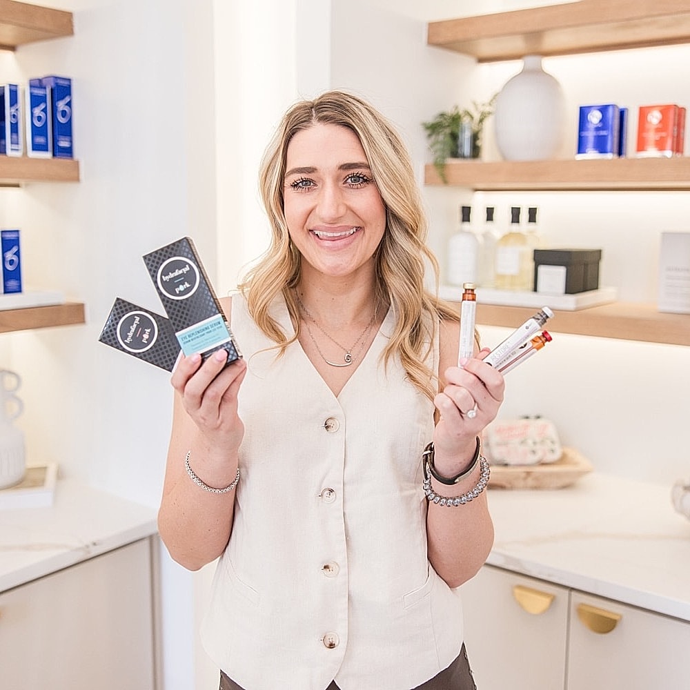 Person holding skincare products in a beauty salon.