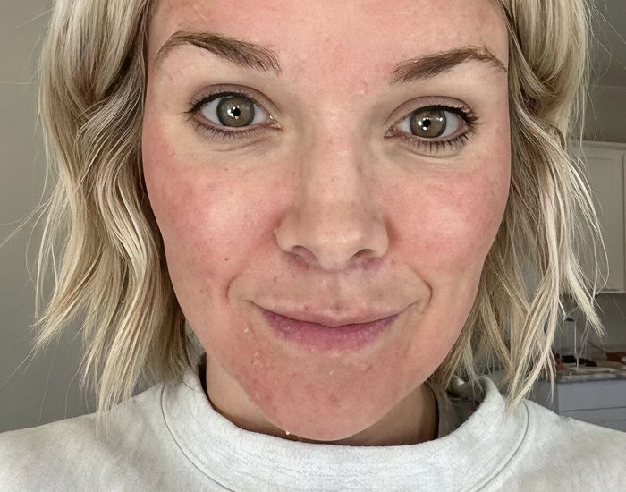 Smiling woman with short blonde hair, natural makeup.