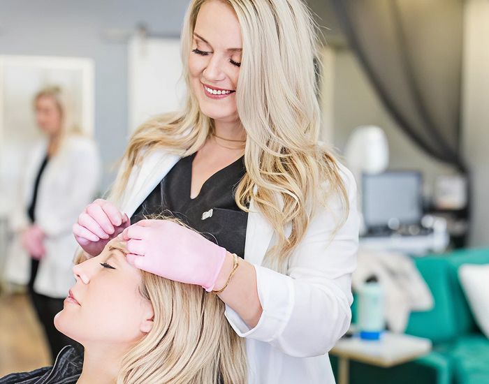 Beauty professional performing treatment on client.