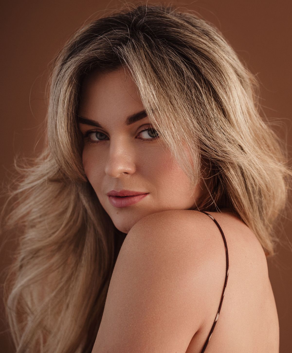 Woman with long hair against a neutral background.