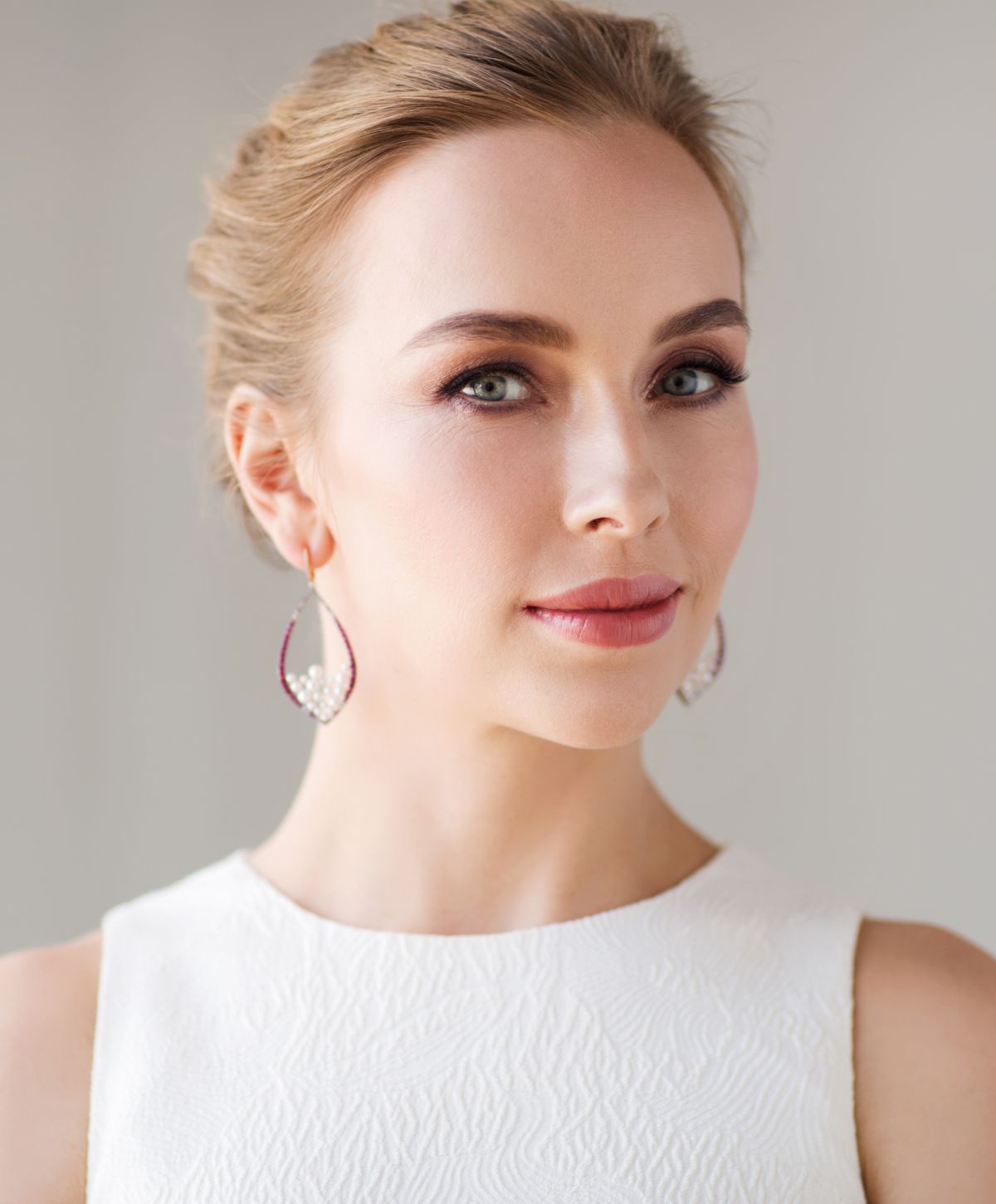 Elegant woman with earrings and natural makeup.