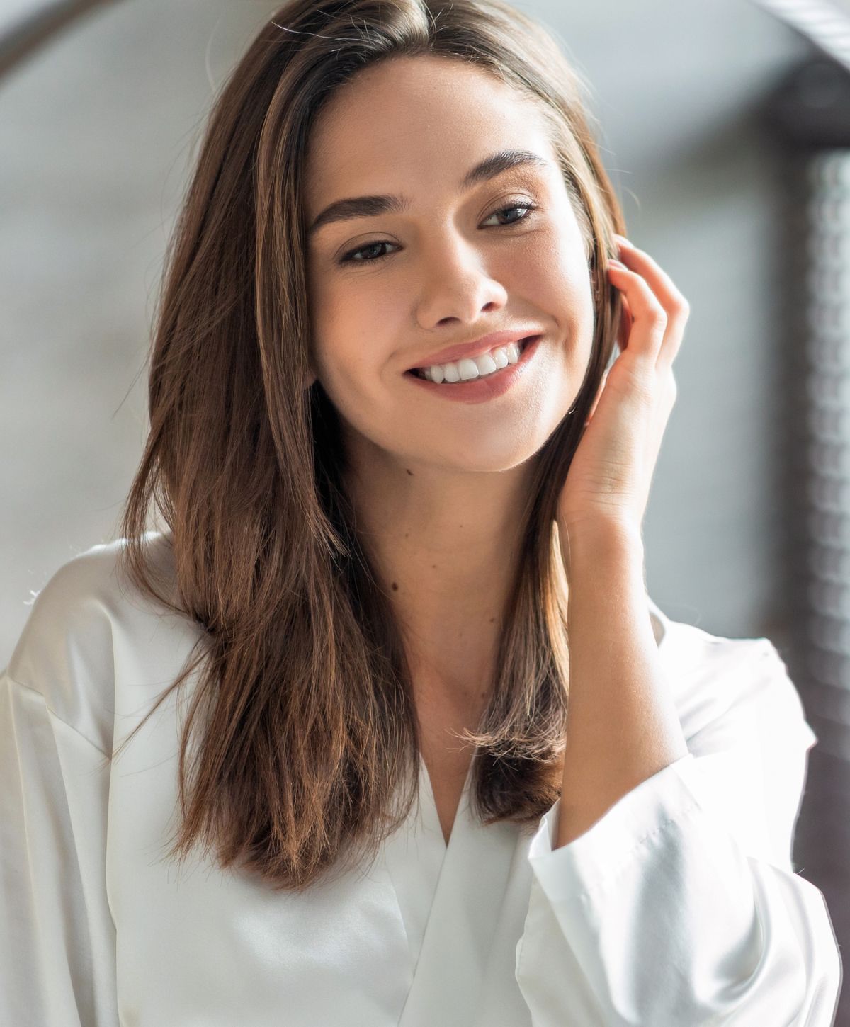Smiling woman in white shirt, natural light.
