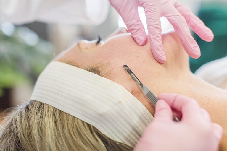 Woman receiving facial treatment in beauty salon.