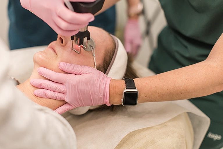 Facial treatment in progress with medical professionals.