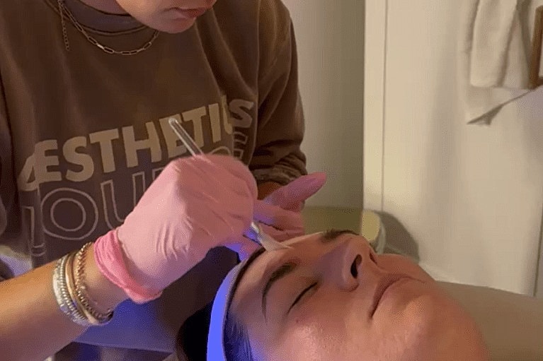 Esthetician performing a facial treatment on client.