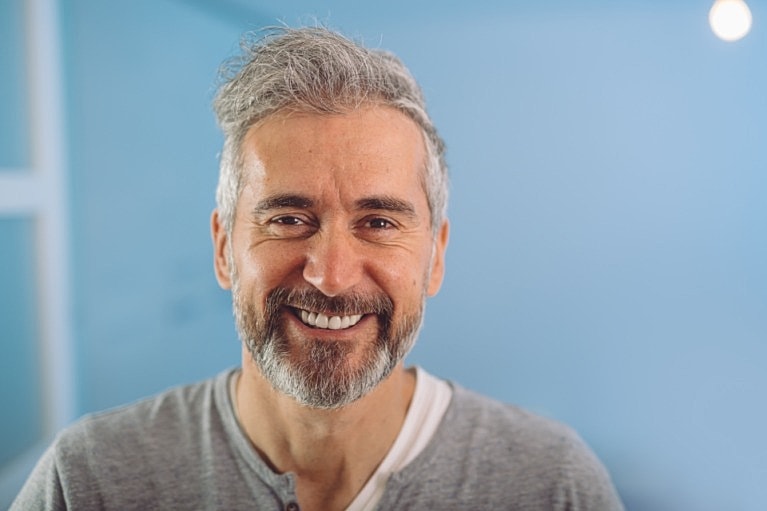 Smiling man with gray hair and beard.