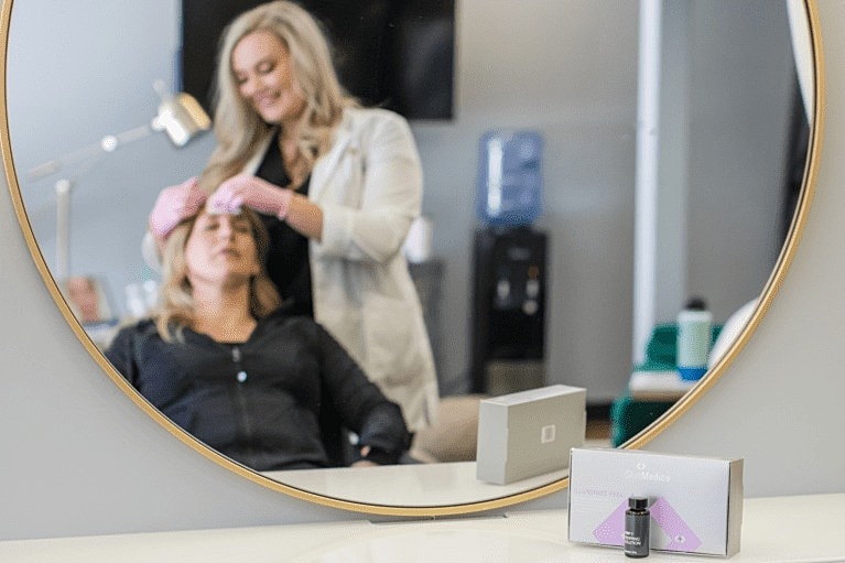 Stylist applying treatment to client's hair.