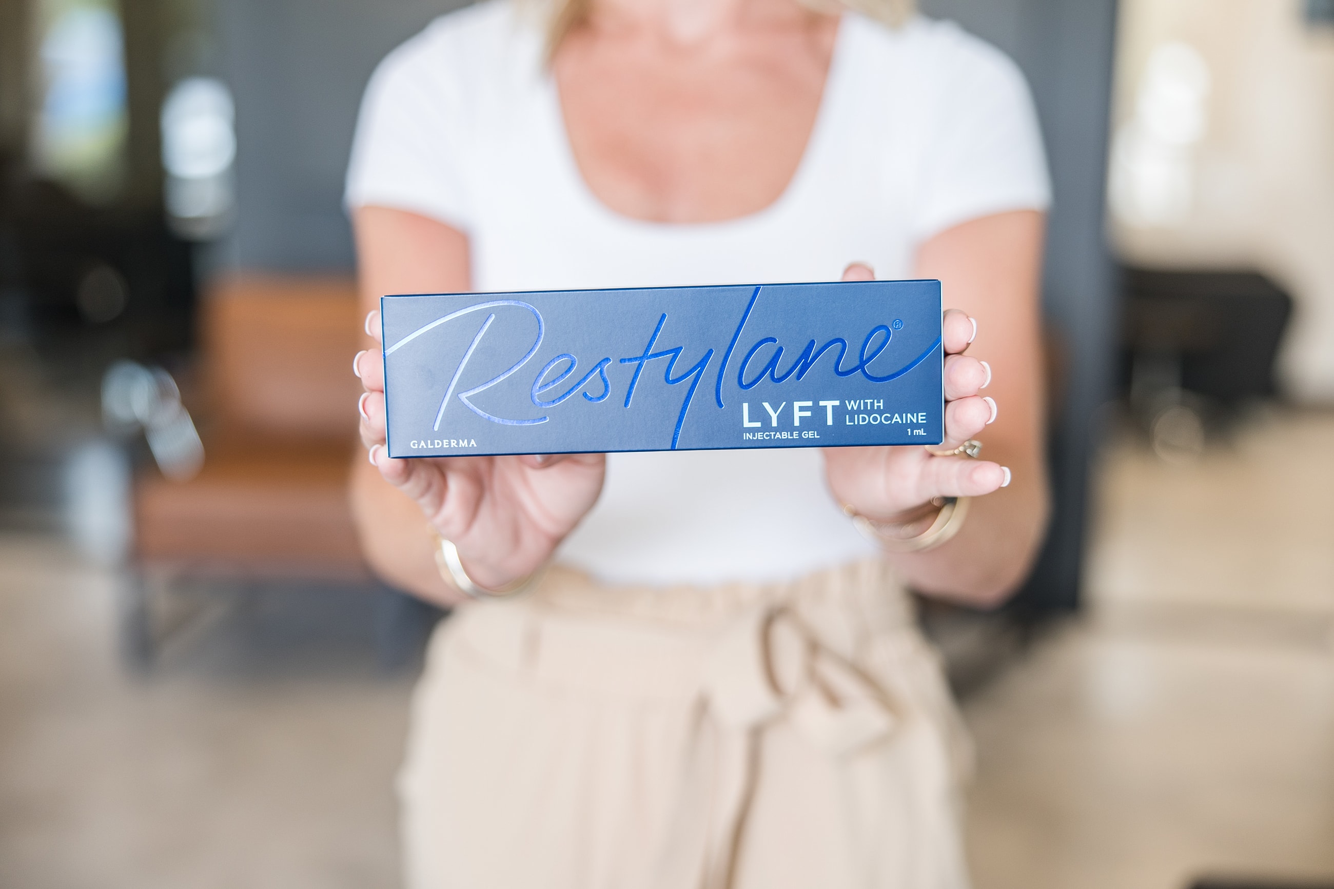 Restylane Lyft injectable gel packaging held by woman