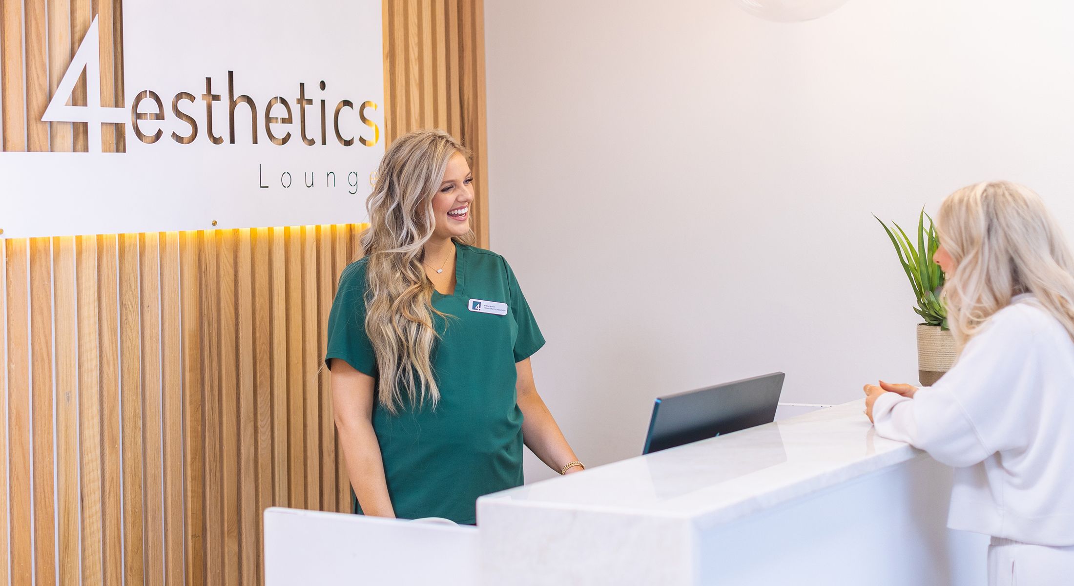 Receptionist assisting a client at aesthetic lounge.
